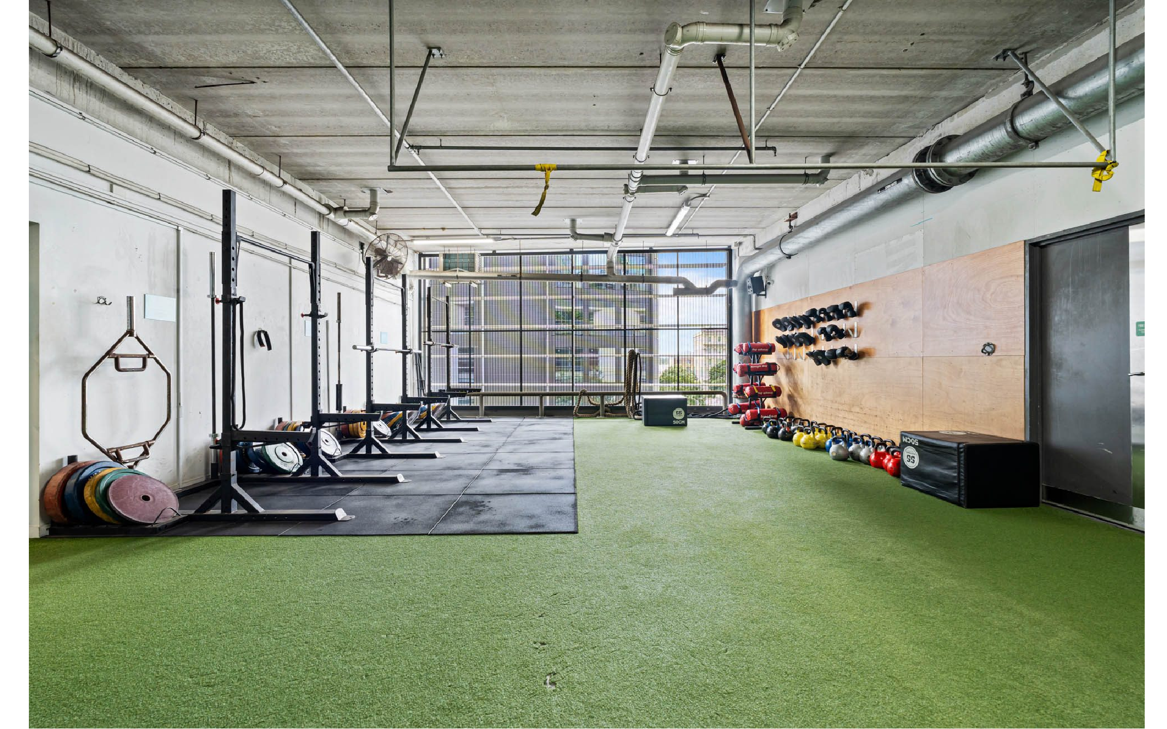 Tortoise outdoor CrossFit zone looking towards Fort Street, with barbells, kettlebells and open turf